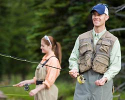 Happy Couple Fly Fishing Together on Mountain Stream
